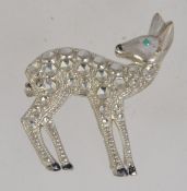A vintage figural brooch pin in the form of a deer fawn with green rhinestone eye and black