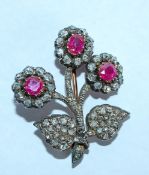 An early 20th century diamond and ruby brooch in the form of a flower spray.