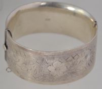 A silver hallmarked large bangle bracelet being rococo chased. Birmingham hallmarks, makers.
