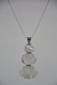 A silver and mother of pearl pendant necklace and chain. The chain measures 15