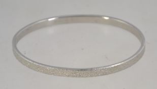 A signed vintage silver tone bangle with textured finish. Signed Monet S.