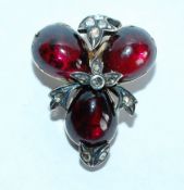 A Victorian 9ct rolled gold mourning brooch decorated with a trefoil of pear drop garnet glass