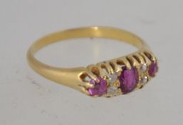 A Victorian 18ct gold ring with oval cut rubies and round cut diamonds in a boat prong setting.