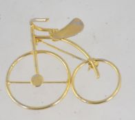 A 1970's bicycle brooch / pendant having gold tone with pendant ball and pin roll over clasp.