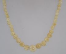 A vintage carved celluloid bead necklace with screw barrel clasp. Measures 16 inches.