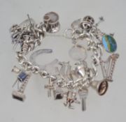 A Sterling silver charm bracelet bearing London hallmarks for 1976 having 20 charms.