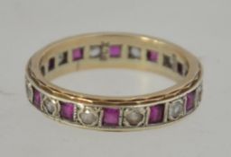 A hallmarked 9ct gold eternity ring set with red and clear gem stones. Hallmarked for Birmingham.