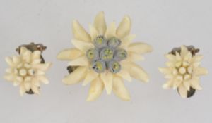 A carved celluloid brooch and clip earrings set in the form of Eidelwiess. Loop clasp on brooch.