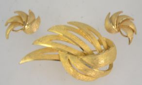 A 1960's vintage brooch and clip earring set by Coro having gold tone with roll over clasp brooch.