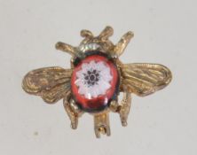 A vintage gold tone bug brooch pin with Murano glass body and roller clasp. Measures 2.5cms.