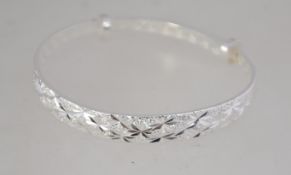 A silver 925 contemporary bangle bracelet with chase decoration of sunbursts. Marked 925. Weight 16.