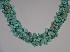 A turqoise cluster chocker necklace with silver tne chain and lobster caw clasp.