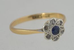 An 18ct gold, sapphire and diamond flower head ring. The 7pnt sapphire surrounded by 1pnt diamonds.
