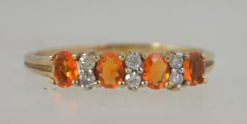 A 9ct gold and diamond ladies ring interspersed with amber colouried garnet stones.