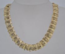 A vintage gold tone choker necklace with textured U links and hook clasp with ball final.