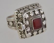 A ethinic silver ring fashioned with a perfume holder set with a central carnelian stone with
