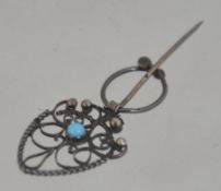 A silver early 20th century Belle Epoque ladies brooch of filigree work inset with turquoise.
