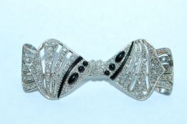 A 1930's 18ct white gold Art Deco bow brooch encrusted with diamonds with trombone clasp.
