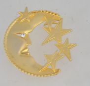 A 1980's large moon and stars brooch having gold tone with single rhinestone and roll over clasp.