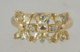 A hallmarked 9ct gold ring set with peridot in a floral setting. Hallmarked Birmingham. Weight 2.9g.