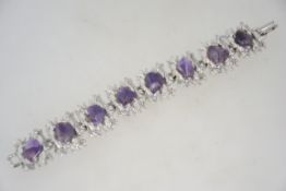A 1970's modernist bracelet having silver tone set with pebble amethysts and having a fold over