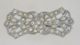 A 1920's / 1930's Art Deco brooch having silver tone with rhinestone settings and loop clasp.