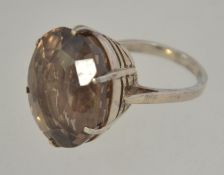 A silver dress ring set with a large smokey quartz in a pierced gallery prong setting.