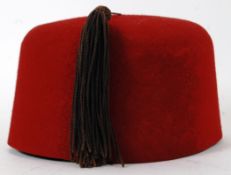MILITARY ISSUE FEZ: A post WWII era 1955 military issue uniform fez hat. Red, with original tassle.