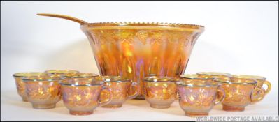 A vintage / retro 20th century Carnival glass punch bowl set to include the bowl cups and hooks