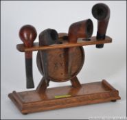 A vintage oak smoking pipe stand with pipes in the form of a barrel.