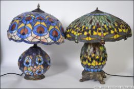 A Tiffany style glass lamp and shade having a dragon fly design along with another of similar form.