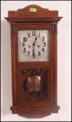 A 20th century oak cased silvered dial eight day movement wall clock with pendulum and glass
