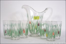 A vintage 1930s lemonade set consisting of jug and six glasses with hand painted tulip design.