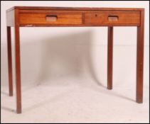 A 1960's Gordon Russell teak desk raised on squared legs with twin drawers taken from Monmouth
