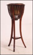 An Edwardian mahogany plant stand having slatted barrel style top with inset liner.