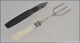 A silver hallmarked three prong pickle fork with mother of pearl handle, assay stamp for Sheffield,