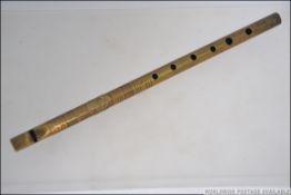 A vintage 20th century brass tin / penny whistle with six holes bearing makers plaque,