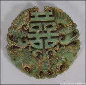 A Chinese Jade roundel of carved form with central geometric design surrounded by Bats.