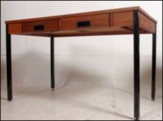 A retro 20th century industrial office factory teak wood desk having two drawers to the front