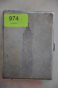 A silver hallmarked cigarette case having an engine turned geometric pattern and Art Deco design,