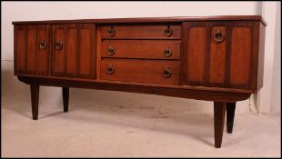 A 1970's retro teak wood sideboard of small proportions being raised on tapered with drawers and