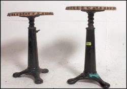 A pair of Victorian late 19th century Century cast metal Singer sewing machine stools having an