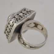 A ethinic silver ring fashioned with a perfume holder set with a central carnelian stone with