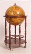 An antique style drinks globe having hinged centre with sectional interior raised on fitted trolley