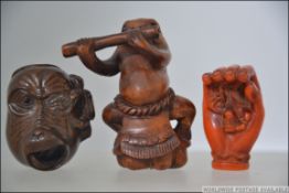 A group of three 20th century Netsukes two of which are carved from hard wood one depicting a