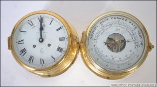 A 20th century antique style Maritime bulkhead of brass clock and brass barometer having brass
