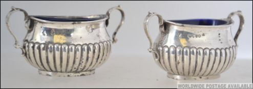 2 19th century silver hallmarked table salts, each with blue glass liners. being twin handled.