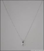 An 18ct white gold and diamond pendant.