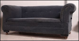 A classic Victorian chesterfield sofa settee upholstered in blue velour fabric with barrel arms and
