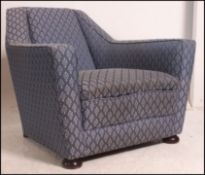 A vintage post war Art Deco club armchair of angular form raised on block feet with blue